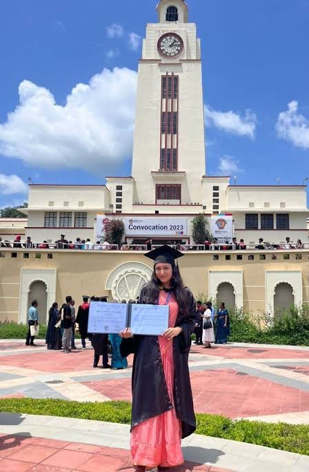 Graduate holding a degree certificate at convocation