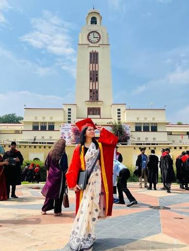 Graduate in convocation robes on campus