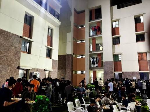 Students gathered in a hostel courtyard in the evening